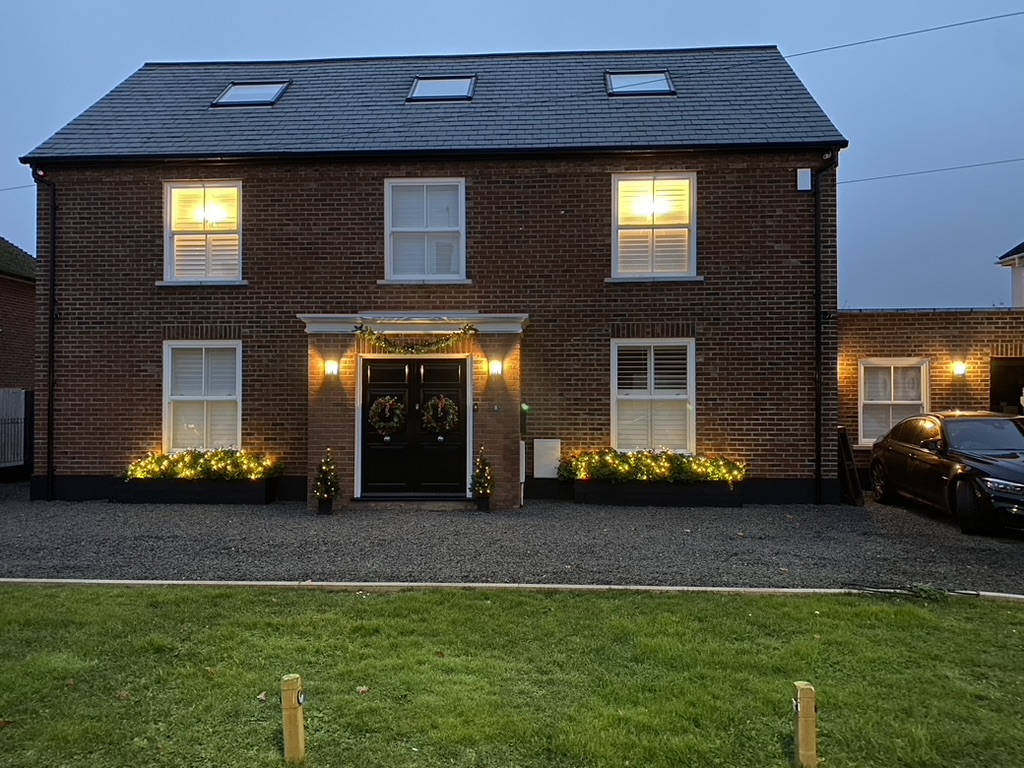 Brick-built family house finished by P1, lit up at dusk