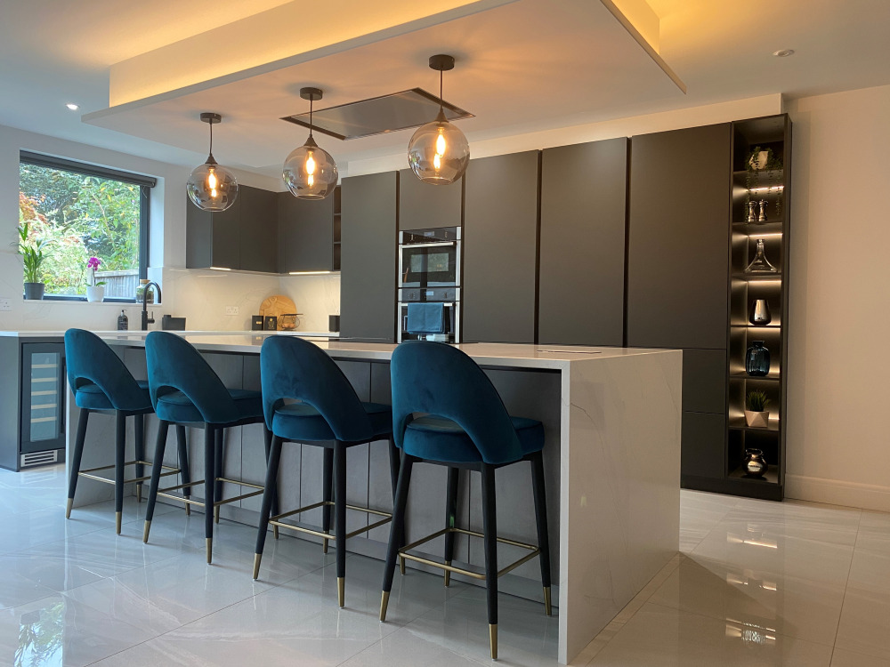 Open-plan kitchen with island, bar stools and pendant lights, fitted by P1